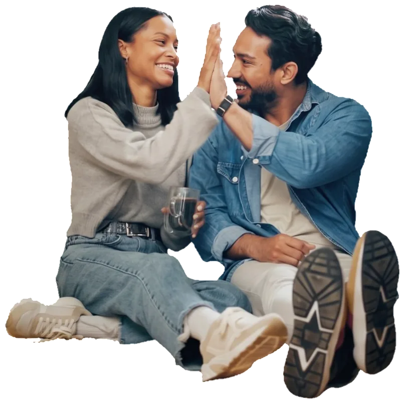 Two partners high-fiving on their kitchen floor